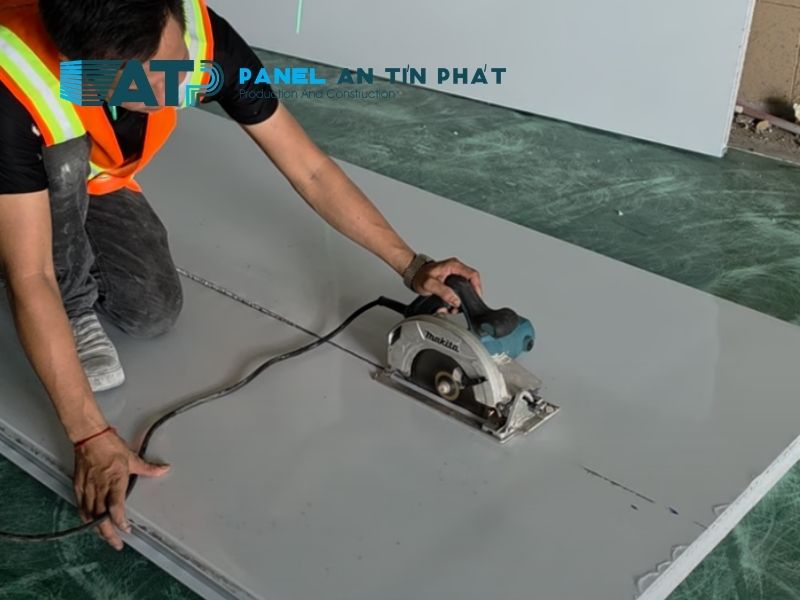 Kỹ thuật viên đo và đánh dấu vị trí cắt tấm panel để mở cửa, ô kính hoặc lỗ kỹ thuật tại công trình