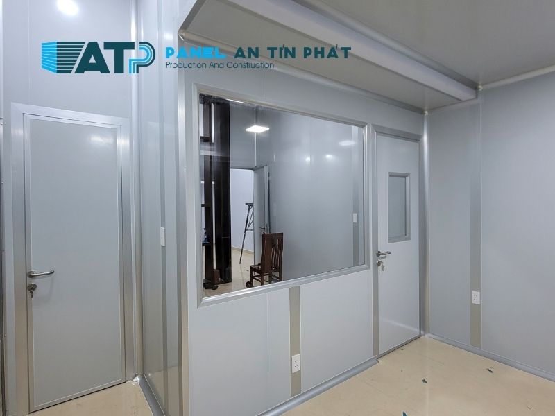 Văn phòng lắp ghép sử dụng vách panel Rockwool, có cửa, cửa sổ, mái che, khung thép và khu vực làm việc bên trong.